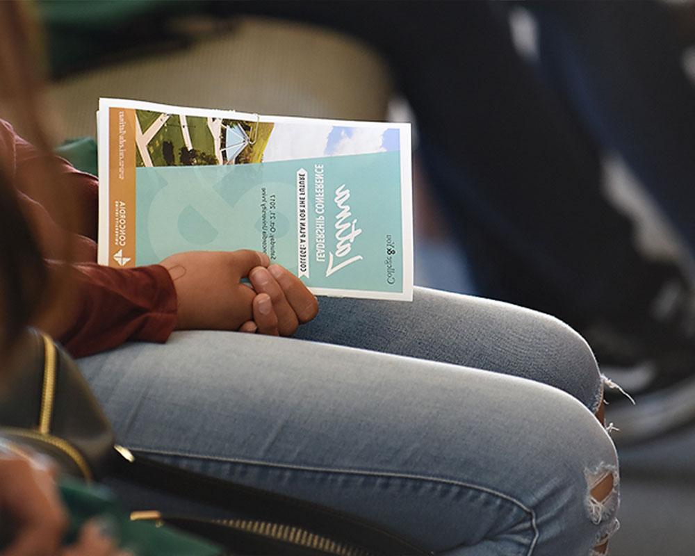 Girl sitting down with conference pamphlet